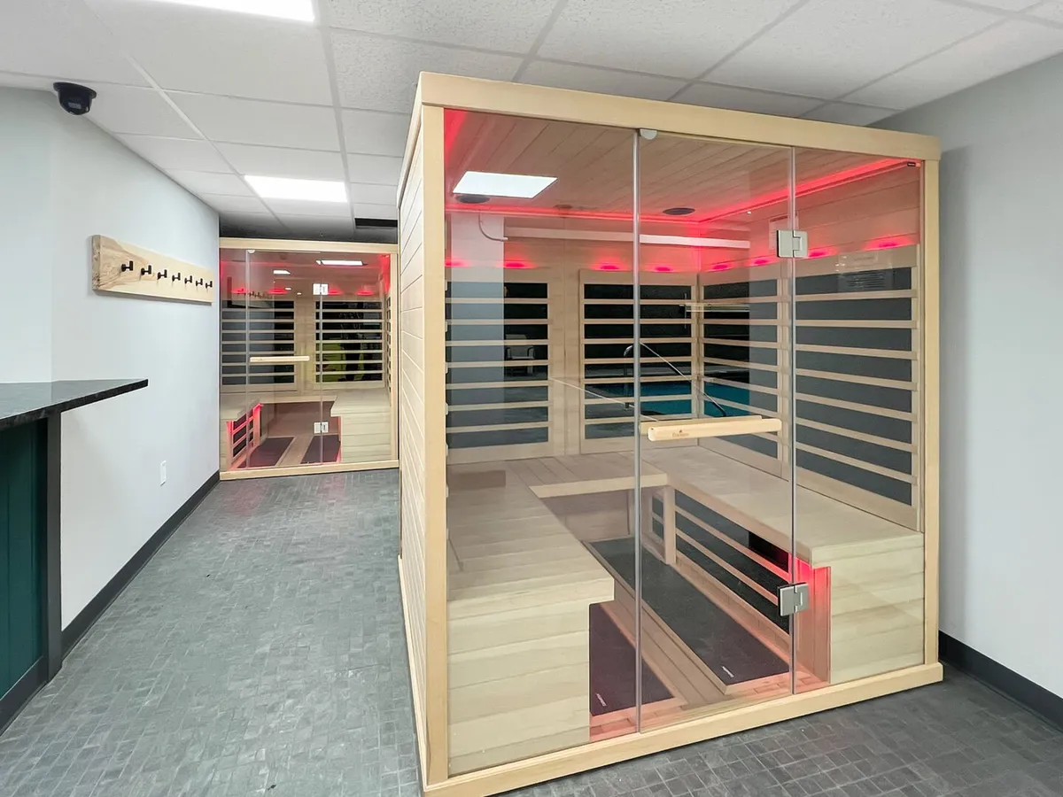 A tranquil sauna area featuring wooden sauna structures, glass doors, and ambient lighting. The mood is peaceful and inviting, suggesting a rejuvenating wellness experience ideal for unwinding after a day of activity.